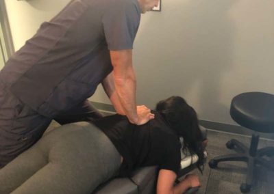 Chiropractor working on a woman's shoulder at Reid Family Wellness